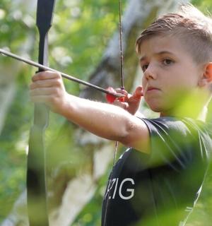 a young boy holding a bow and arrow
