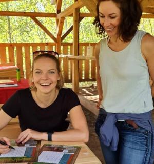 two women are standing next to a table