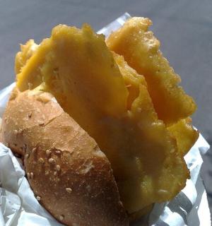 eine Person, die ein Stück Essen mit Käse hält