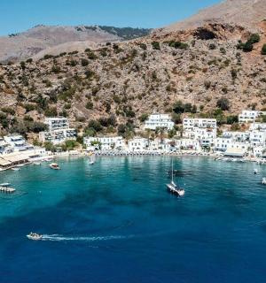 an aerial view of a beach with blue water and white buildings