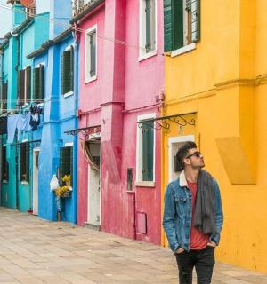 muž stojící před barevnou budovou