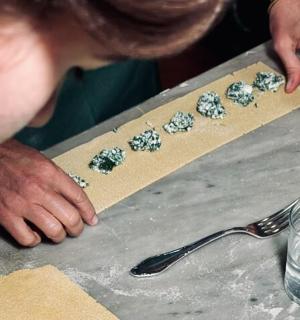 一名男子正在用勺子在桌子上做饼干