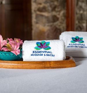 两条毛巾放在放着鲜花的桌子上