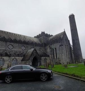 černé auto zaparkované před starým kostelem