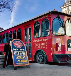 a red bus is parked next to a sign