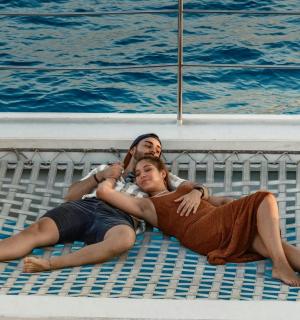 两名男子躺在游泳池边的水边
