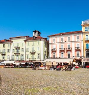 a group of buildings with tables and chairs in a street