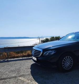 一辆黑色汽车停在海边的路上