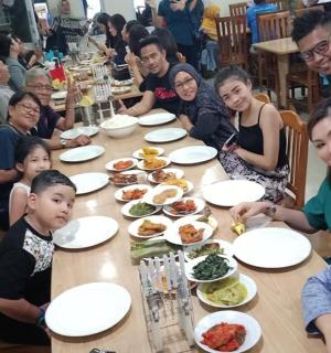 一群人坐在桌旁吃饭