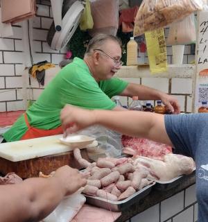 两名妇女正在市场准备肉