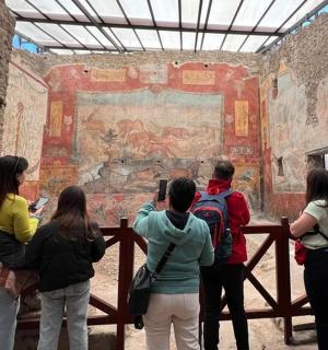 a group of people looking at a painting in aiseum