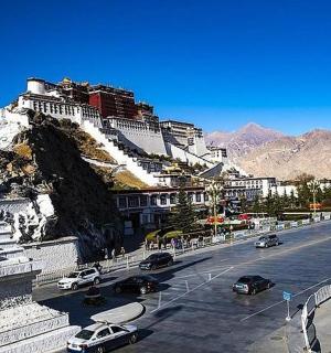 ulice s auty zaparkovanými na úbočí hory