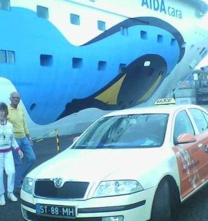 a man and a woman standing next to a car next to an airplane