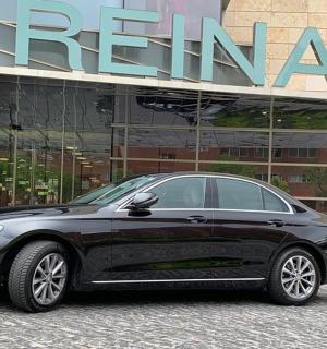 一辆黑色汽车停在一栋建筑物前