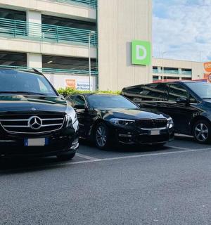 tři auta zaparkovaná na parkovišti před budovou