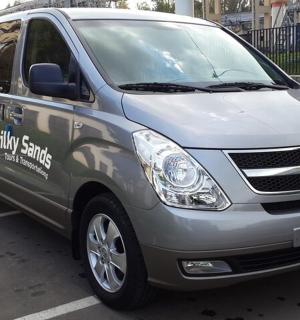 一辆银色的穿梭巴士停在停车场