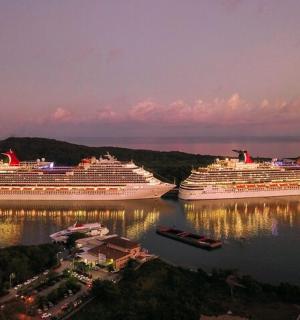 three cruise ships docked in the water at night
