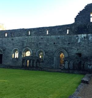 an old stone building with a green lawn in front