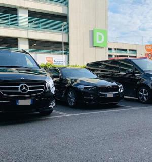 三辆汽车停在一栋建筑前的停车场