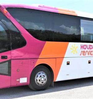 a pink and orange bus parked in a parking lot