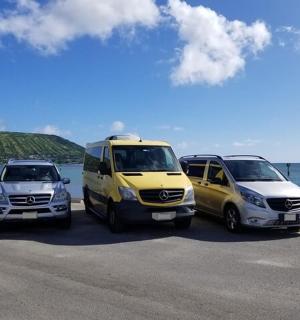 three vehicles parked in a parking lot next to the ocean