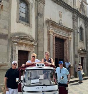 a group of people standing next to an old car