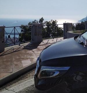 un'auto nera parcheggiata accanto a un balcone con vista sull'oceano