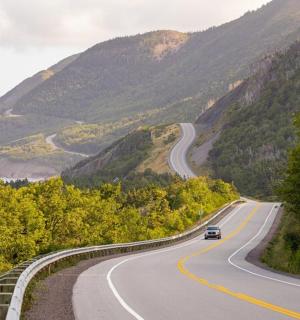 a car driving down a winding road in the mountains