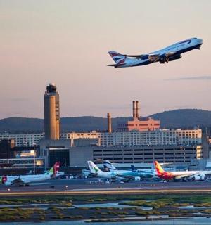 an airplane is flying over an airport with planes
