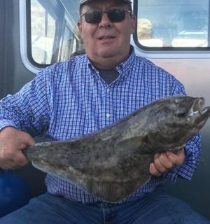 一名男子手里拿着一条大鱼