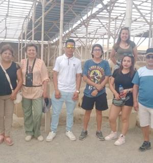 skupina lidí pózujících pro fotografii před ovcemi