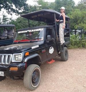 a woman standing on the back of a jeep