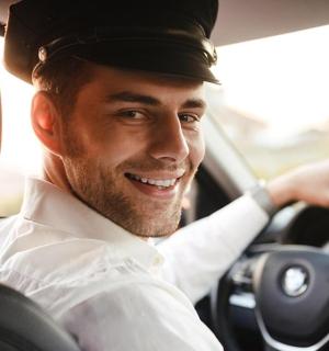 a man is smiling while driving a car