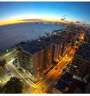 an aerial view of a city and the ocean at night