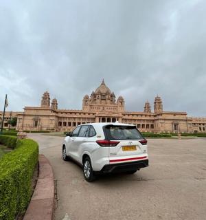 一辆白色汽车停在一栋大楼前