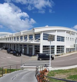 a large white building with cars parked in a parking lot