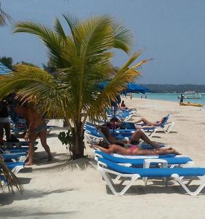 a group of people laying in lawn chairs on a beach