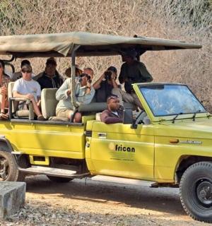 skupina lidí jedoucích v zadní části džípu