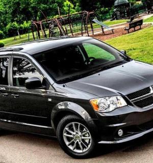 一辆黑色 SUV 停在带游乐场的公园里