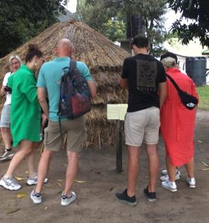 一群人站在茅草屋前