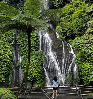 a woman standing in front of a waterfall