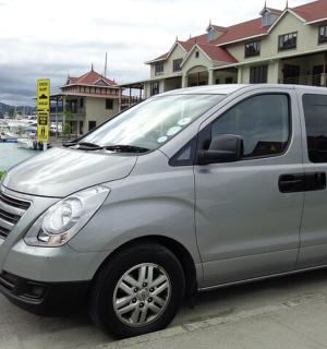 a silver van parked in front of a marina
