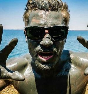 muž se zdviženýma rukama na pláži