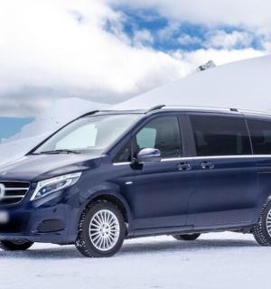 a blue van parked in a snow covered field