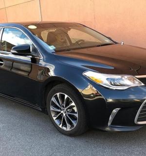 a blue and black car parked next to a building