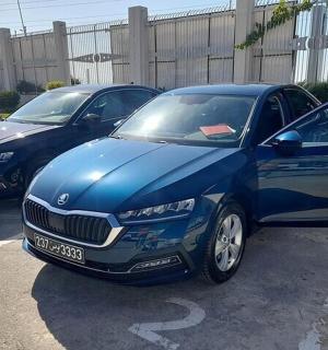 two blue cars parked in a parking lot