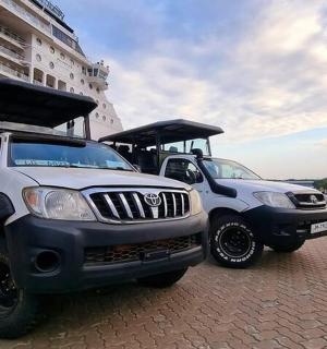 two trucks parked next to a cruise ship