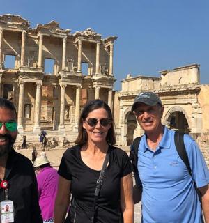 two men and a woman standing in front of the coliseum
