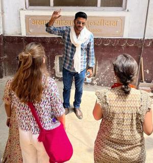three people standing around a man waving at a train