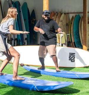 一名男子和一名女子站在冲浪板上